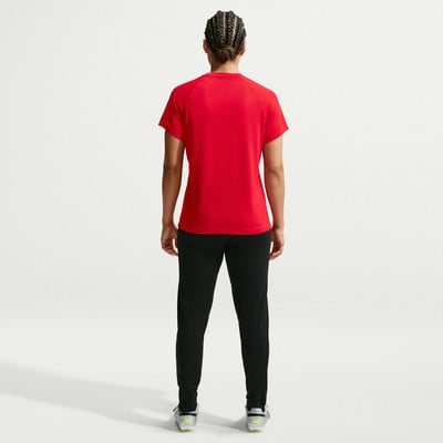 Rückansicht einer Person in einem roten T-Shirt und schwarzen Hosen.