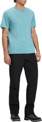 Ein Mann in einem blauen T-Shirt und schwarzer Hose mit Stiefeln.