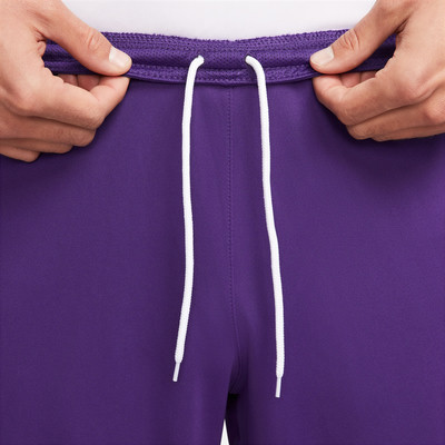 Detail einer violetten Herrenhose mit weißem Kordelzug. Detail einer violetten Herrenhose mit weißem Kordelzug.