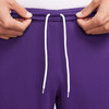 Detail einer violetten Herrenhose mit weißem Kordelzug.