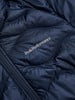 Detail einer dunkelblauen Daunenjacke mit Peak Performance Logo und Reißverschluss.