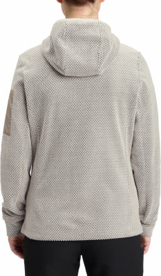 Rückansicht einer Person in einem beigefarbenen Kapuzenpullover mit Muster. Rückansicht einer Person in einem beigefarbenen Kapuzenpullover mit Muster.