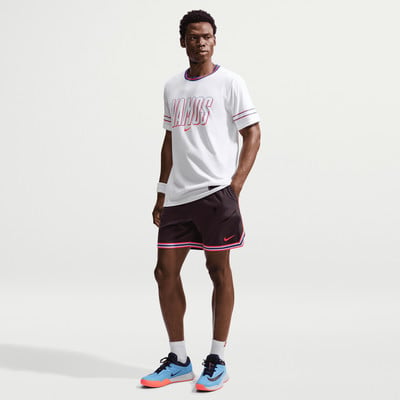 Ein Mann in einem weißen T-Shirt mit Aufdruck und schwarzen Shorts posiert. Ein Mann in einem weißen T-Shirt mit Aufdruck und schwarzen Shorts posiert.