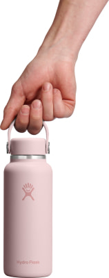 Eine Hand hält eine rosafarbene Hydro Flask Flasche am Griff.