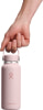 Eine Hand hält eine rosafarbene Hydro Flask Flasche am Griff.