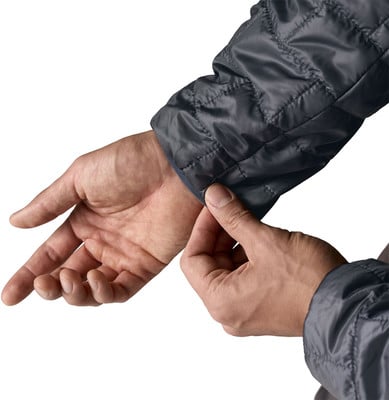 Ein Mann zieht den Ärmel einer Jacke über sein Handgelenk auf weißem Hintergrund.
