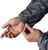 Ein Mann zieht den Ärmel einer Jacke über sein Handgelenk auf weißem Hintergrund.