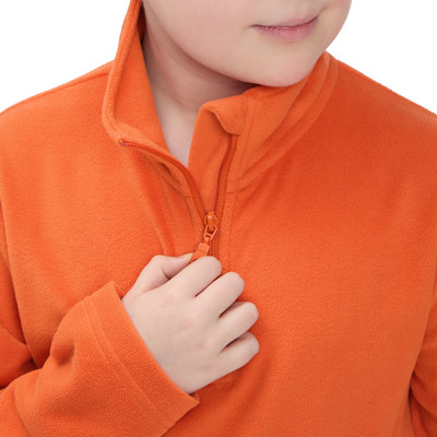 Ein Kind schließt einen orangefarbenen Fleece-Pullover am Kragen. Ein Kind schließt einen orangefarbenen Fleece-Pullover am Kragen.