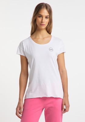 Ein Mädchen in einem weißen T-Shirt mit Rundhalsausschnitt und pinker Jogginghose.
