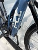 Detail eines E-Mountainbikes mit Logo und Dämpfer.