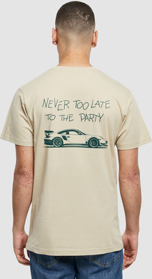 Auf einem beige T-Shirt ist eine grüne Schrift und ein Sportwagen abgebildet. Auf einem beige T-Shirt ist eine grüne Schrift und ein Sportwagen abgebildet.