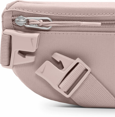 Detail einer rosa Nike Bauchtasche mit Reißverschluss und Kunststoffschnallen. Detail einer rosa Nike Bauchtasche mit Reißverschluss und Kunststoffschnallen.