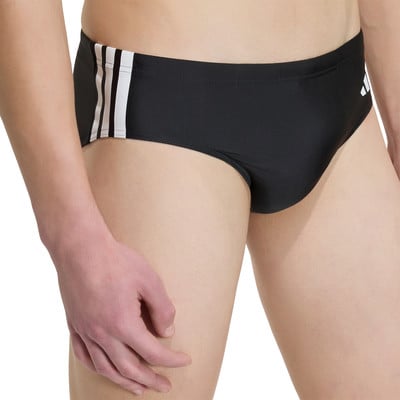 Detail einer schwarzen Adidas Badehose für Herren mit weißen Streifen. Detail einer schwarzen Adidas Badehose für Herren mit weißen Streifen.