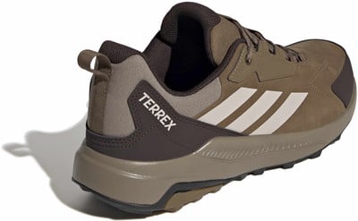 Hnědá turistická obuv Adidas Terrex s bílými pruhy a logem. Hnědá turistická obuv Adidas Terrex s bílými pruhy a logem.