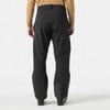 Ein Mann in schwarzer Skihose und brauner Jacke steht von hinten.