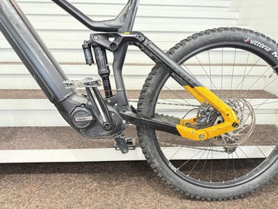 Detail eines E-Mountainbikes mit Federung und gelben Elementen. Detail eines E-Mountainbikes mit Federung und gelben Elementen.