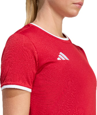 Rotes Adidas-T-Shirt mit weißem Kragen und Logo auf der Brust. Rotes Adidas-T-Shirt mit weißem Kragen und Logo auf der Brust.
