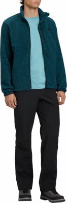 Ein Mann in einem dunkelblauen Fleece-Pullover und schwarzen Hosen. Ein Mann in einem dunkelblauen Fleece-Pullover und schwarzen Hosen.