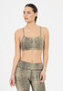Eine Frau in einem leopardbedruckten Sport-BH und Leggings blickt nach rechts.