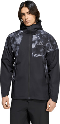 Ein Mann in einer schwarzen Jacke mit Aufdruck und Adidas-Logo vor weißem Hintergrund. Ein Mann in einer schwarzen Jacke mit Aufdruck und Adidas-Logo vor weißem Hintergrund.