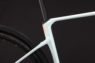 Detail eines Fahrradrahmens mit einem beige Streifen und schwarzem Reifen. Detail eines Fahrradrahmens mit einem beige Streifen und schwarzem Reifen.
