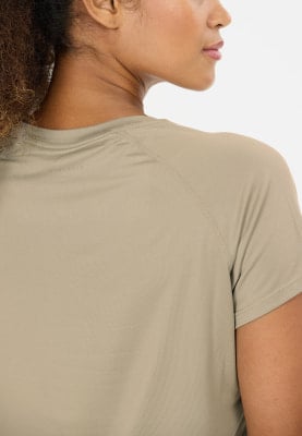 Detail des Nackens und der Schultern einer Frau in einem beigen T-Shirt. Detail des Nackens und der Schultern einer Frau in einem beigen T-Shirt.