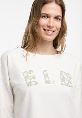 Model in weißem Pullover mit ELB-Aufdruck auf der Brust. Model in weißem Pullover mit ELB-Aufdruck auf der Brust.