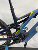 Detail des hinteren Teils eines blauen E-Bikes mit Dämpfer und Kette.
