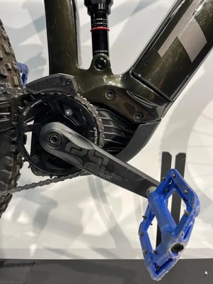 Detail eines Mountainbike-E-Bikes mit Kurbeln und blauem Pedal. Detail eines Mountainbike-E-Bikes mit Kurbeln und blauem Pedal.