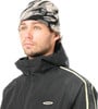 Ein junger Mann in einer schwarzen Kapuzenjacke und einer Camouflage-Mütze mit Logo.