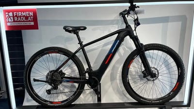 Schwarzes Genesis E-Bike mit roten und blauen Akzenten auf Rahmen und Rädern. Schwarzes Genesis E-Bike mit roten und blauen Akzenten auf Rahmen und Rädern.
