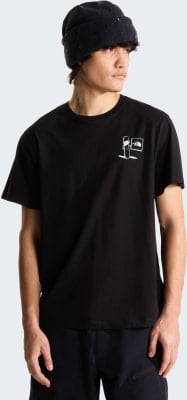 Ein Mann in einem schwarzen T-Shirt mit einem Snowboarder-Aufdruck und dem North Face Logo. Ein Mann in einem schwarzen T-Shirt mit einem Snowboarder-Aufdruck und dem North Face Logo.