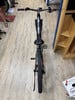 Ein Mountainbike steht auf einem Holzboden neben einem Regal.