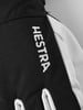 Detail eines Hestra-Handschuhs mit weißem Logo auf schwarzem Hintergrund.