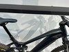 Teil eines schwarzen E-Mountainbikes mit Federung und gedämpftem Sattel.
