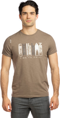Mann in braunem T-Shirt mit Berg- und Waldmotiv, Aufschrift „Time to Chill“. Mann in braunem T-Shirt mit Berg- und Waldmotiv, Aufschrift „Time to Chill“.