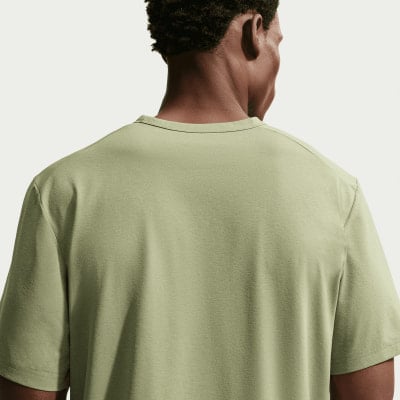 Rückansicht eines Mannes in einem hellgrünen T-Shirt.