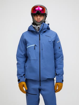Ein Skifahrer präsentiert eine blaue Jacke und Hose mit Helm und Brille. Ein Skifahrer präsentiert eine blaue Jacke und Hose mit Helm und Brille.