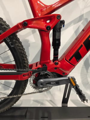 Detail der Hinterradfederung und SRAM GX-Kurbel an einem roten E-Bike. Detail der Hinterradfederung und SRAM GX-Kurbel an einem roten E-Bike.