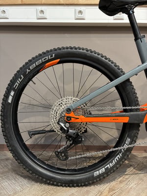 Hinterrad eines E-Mountainbikes mit orangefarbenen Details und BOSCH Antrieb. Hinterrad eines E-Mountainbikes mit orangefarbenen Details und BOSCH Antrieb.