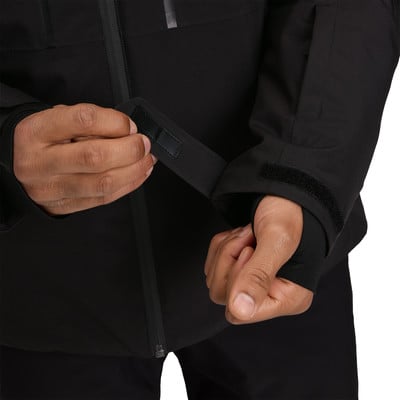 Muž si utahuje suchý zip na rukávu bundy pro lepší přizpůsobení.
