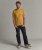 Ein Mann in einem gelben T-Shirt und schwarzer Hose mit Skischuhen.