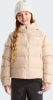 Ein Mädchen in einer beigen Daunenjacke und weißer Mütze mit langen blonden Haaren.