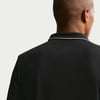 Rückansicht eines Mannes in einem schwarzen Polohemd mit weißer Kragenpaspel.