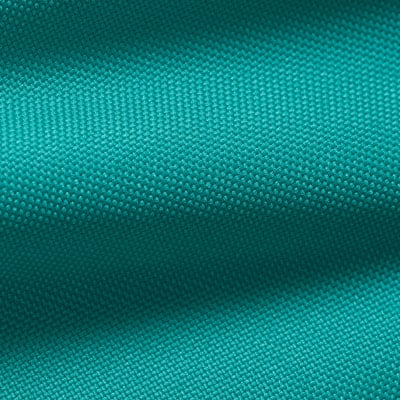 Detail textury látky v tyrkysovém odstínu s jemným vzorováním. Detail textury látky v tyrkysovém odstínu s jemným vzorováním.