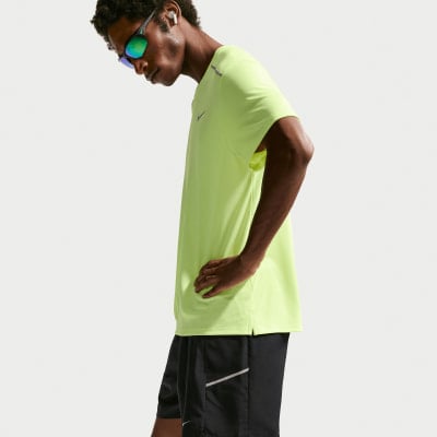 Ein Mann in einem neongelben T-Shirt und schwarzer Shorts mit einer Hand in der Hüfte. Ein Mann in einem neongelben T-Shirt und schwarzer Shorts mit einer Hand in der Hüfte.