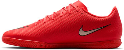 Červená futbalová obuv s béžovým logom Nike a textúrovaným povrchom. Červená futbalová obuv s béžovým logom Nike a textúrovaným povrchom.