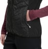 Detail einer gesteppten schwarzen Weste mit einer Hand in der Tasche, weißem Reißverschluss.
