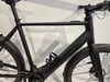 Schwarzes E-Bike mit dunklem Rahmen und Schutzblechen.