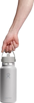 Eine Hand hält eine graue Hydro Flask Flasche mit Henkel. Eine Hand hält eine graue Hydro Flask Flasche mit Henkel.
